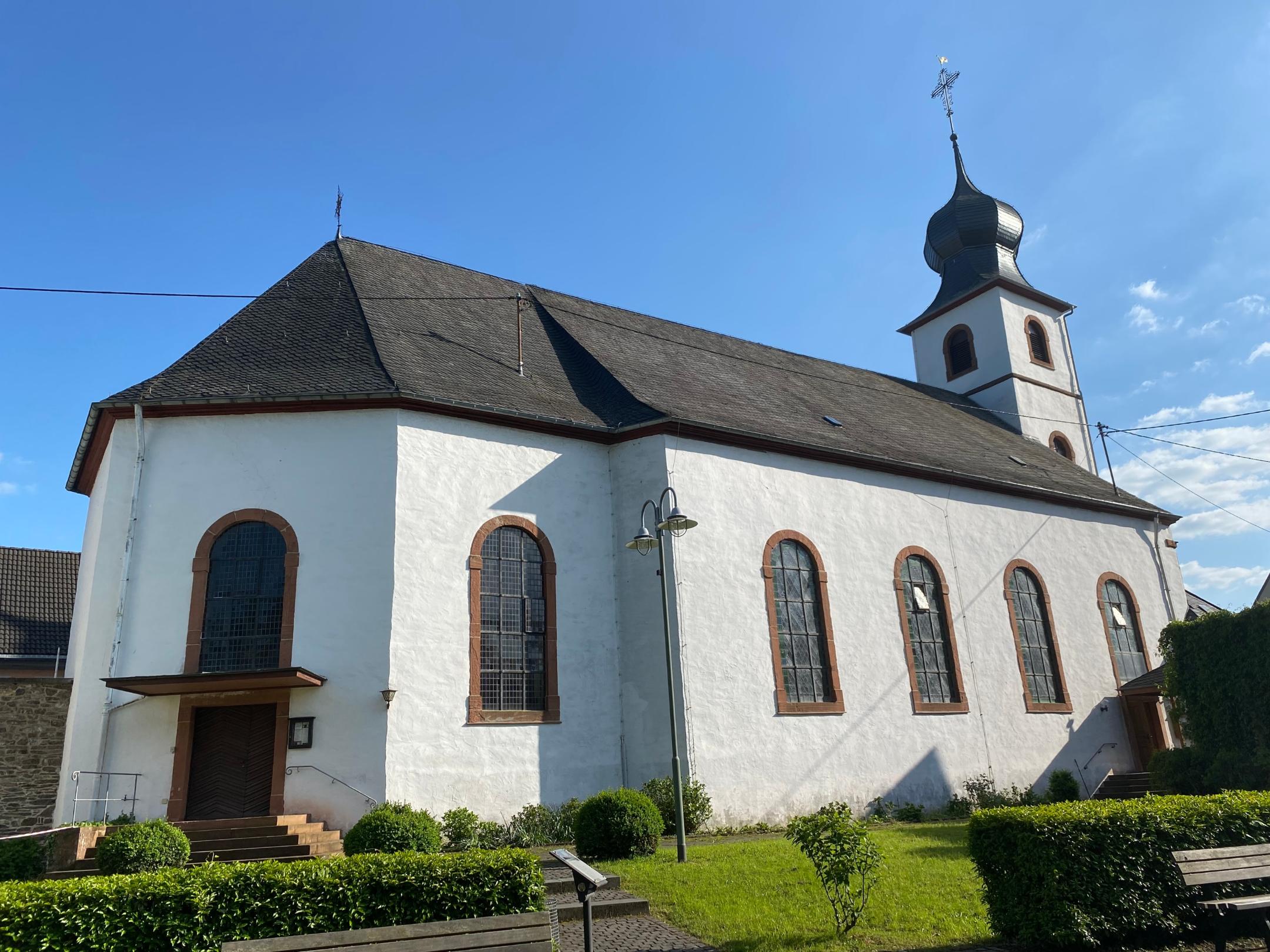 Brauneberg St. Remigius 01 - Die Simultankirche von der Moselseite aus gesehen. Links am Chorbau der Eingang in den evangelischen Kirchenraum, rechts am turmseitigen Ende des Schiffs der Eingang in den katholischen Teil.